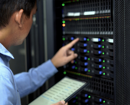 An It Professional In A Blue Shirt Manages And Monitors Network Servers In A Data Center