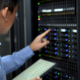 An It Professional In A Blue Shirt Manages And Monitors Network Servers In A Data Center