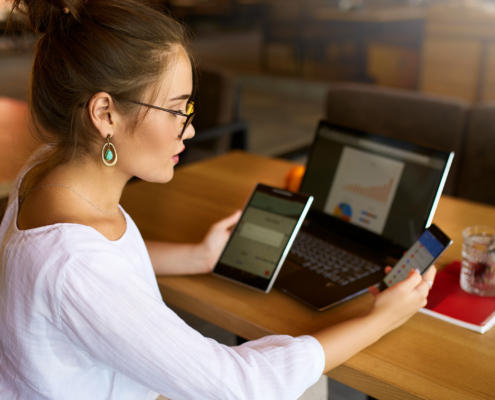 Side View Of Woman In Glasses Working With Multiple Electronic Internet Devices
