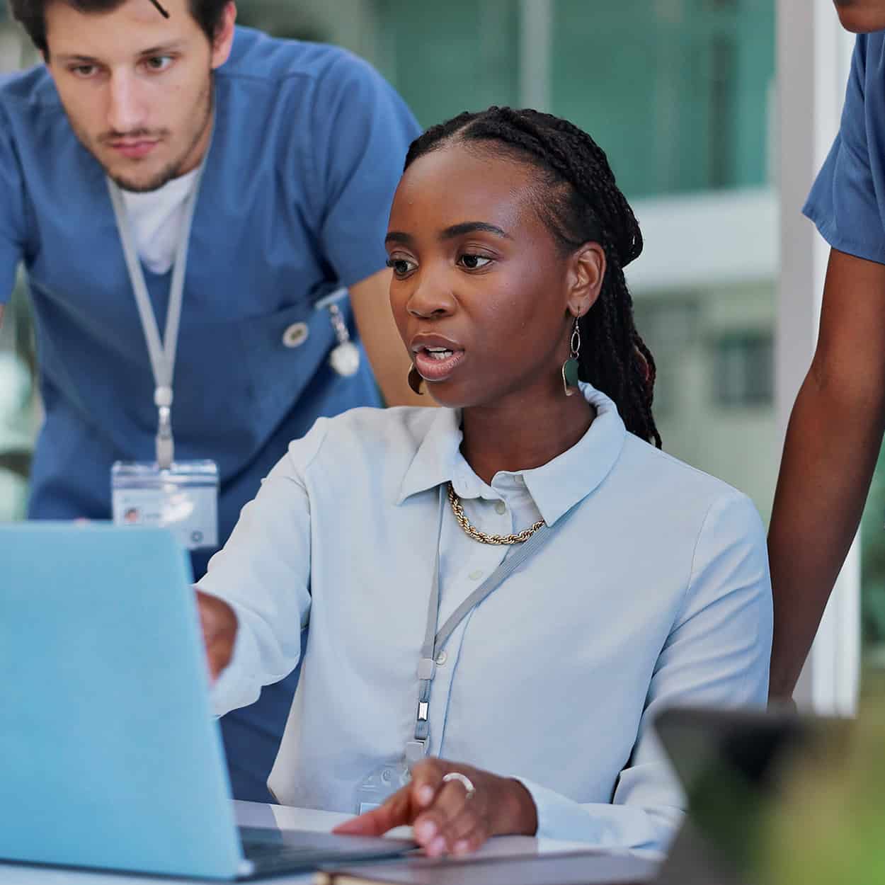 Header Side View Of It Professional Talking To Her Coworkers While On Laptop