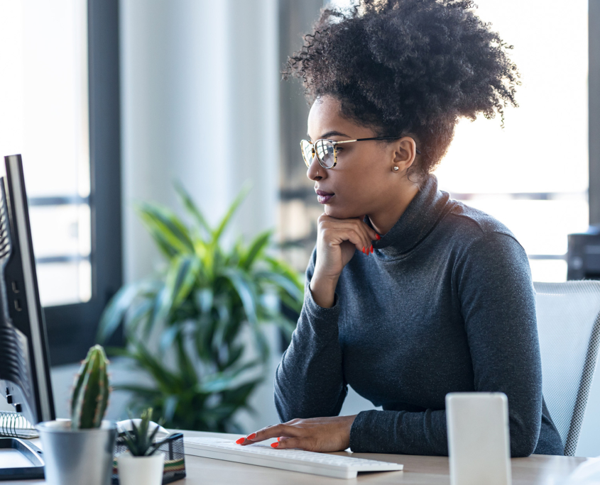 Side View Of Woman Looking At Computer And Typing On Keyboard