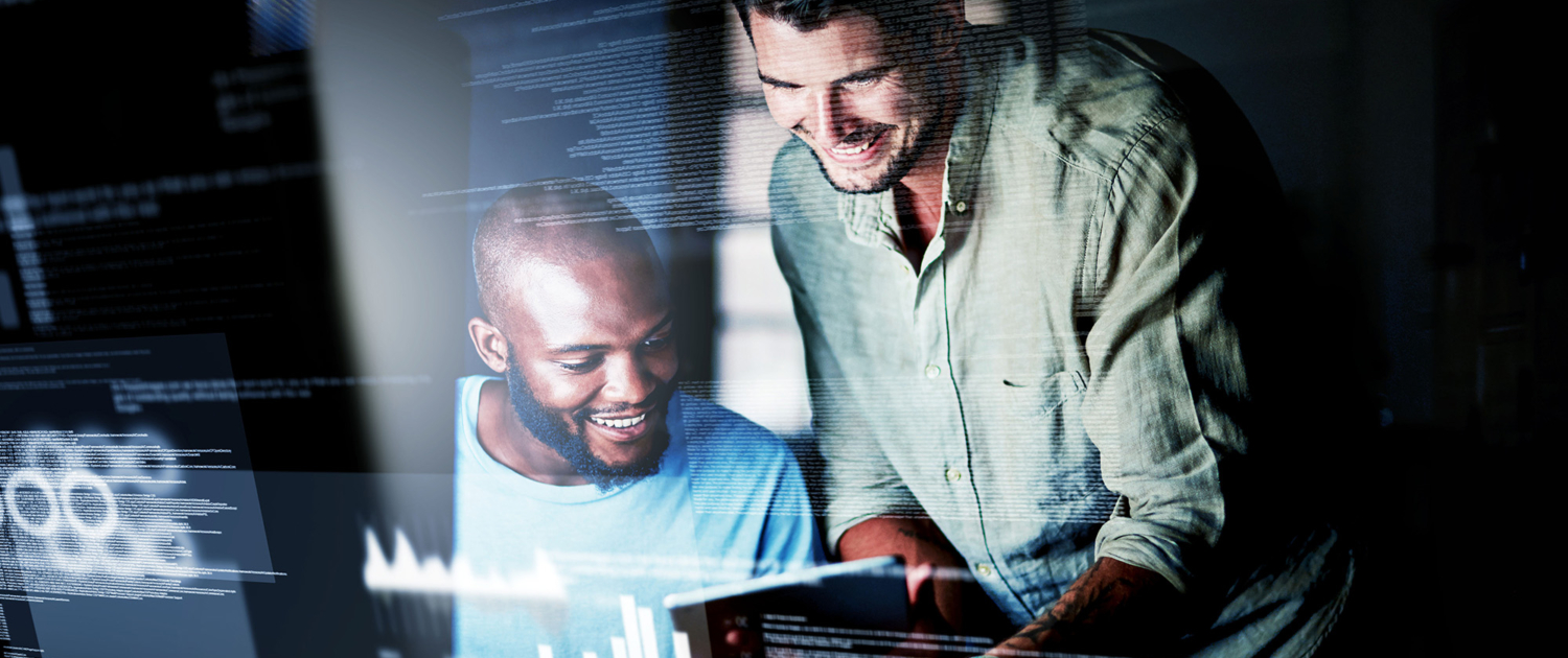 Front View Of Two Smiling Men Looking At Computer With Text Overlayed On Image