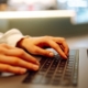 Close-up of hands working on a laptop keyboard