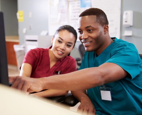 Two healthcare professionals working together at a computer