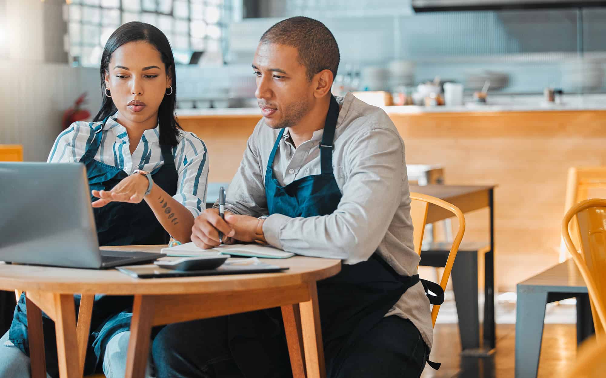 Cafe Store Owners Planning Budget, Brainstorming Coffee Shop Innovation Strategy On Laptop